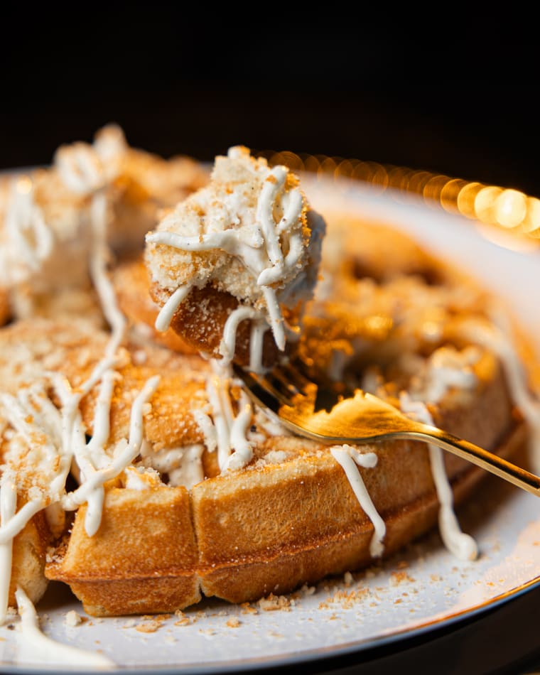 A forkful lifted from a loaded waffle