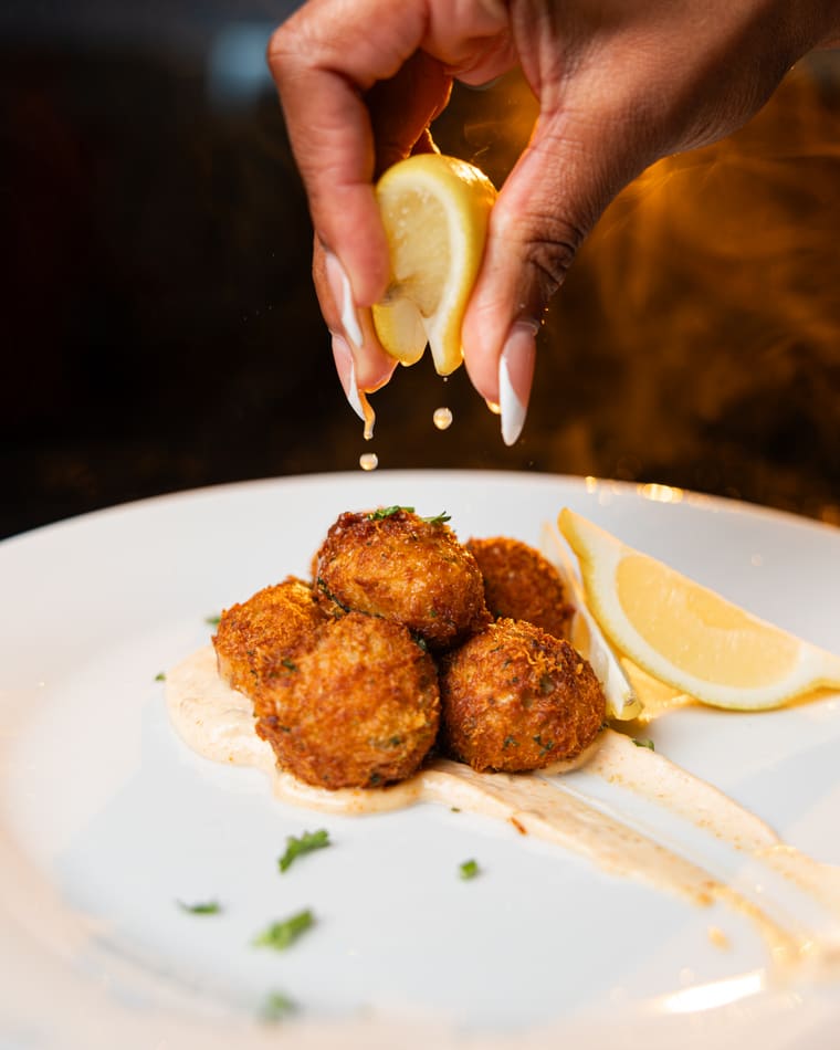 A squeeze of lemon over fried croquettes